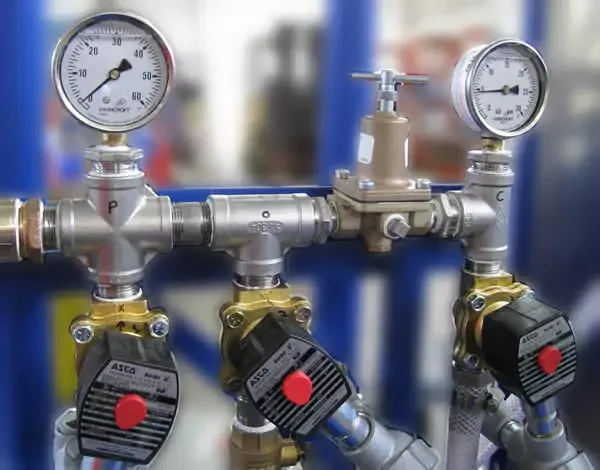 Disc stack centrifuge water harness with solenoids, flow control valves, and pressure-reducing valves