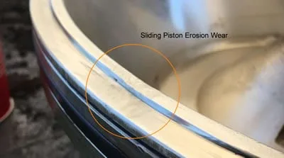 Centrifuge sliding piston showing erosion damage from abrasive process fluid requiring repair or replacement
