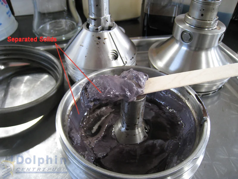 Separated solids collected in the centrifuge bowl after chemical slurry testing